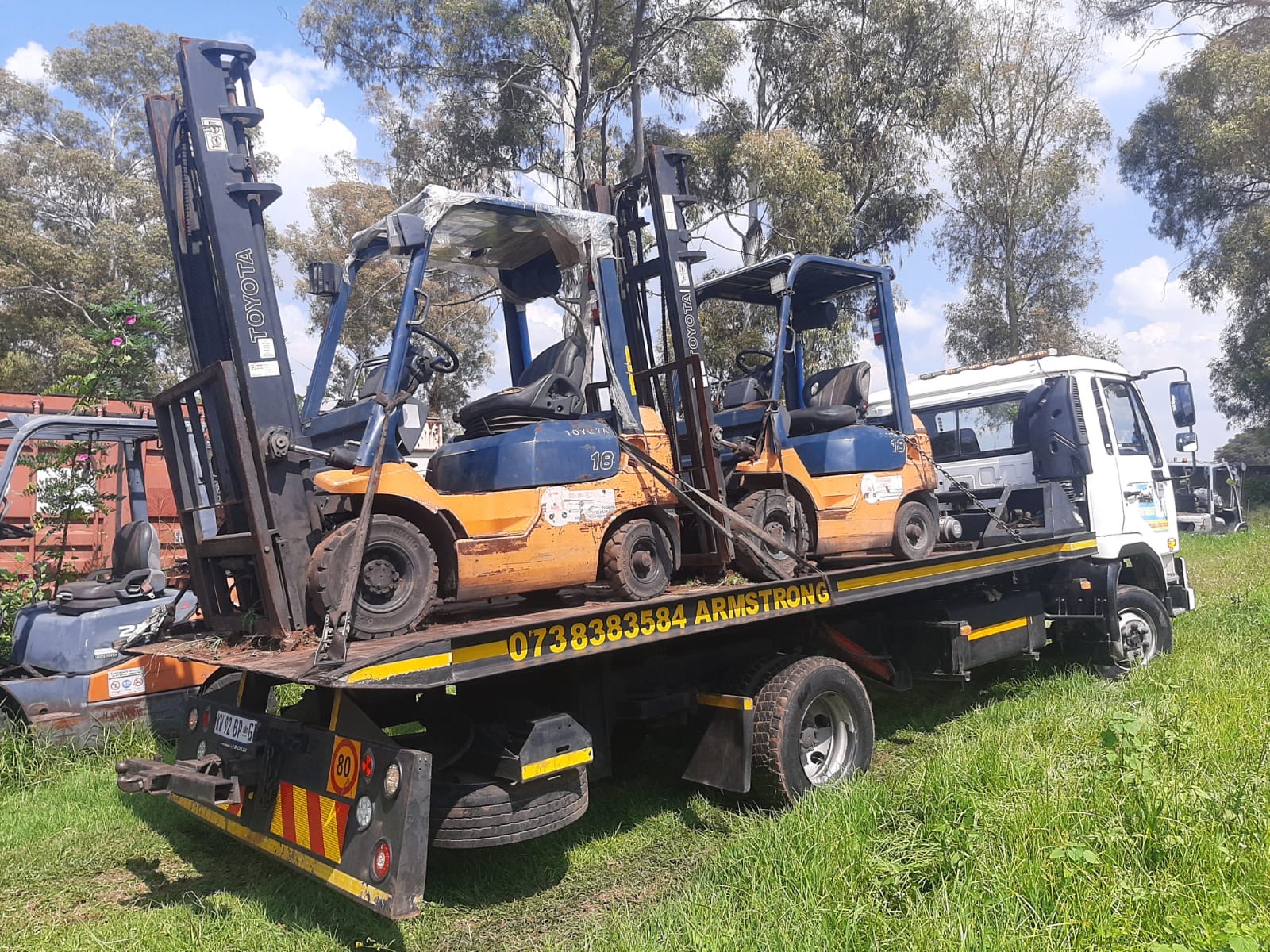 Two Toyota forklifts chained onto the Armstrong Towing flatbed